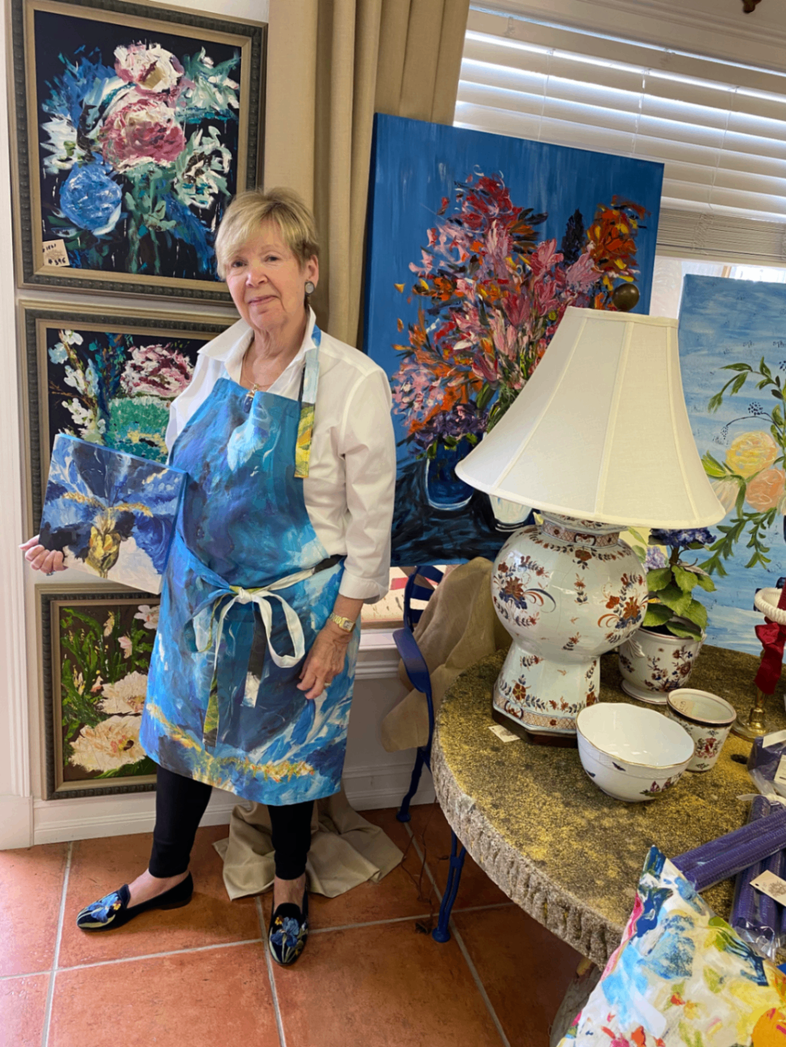 Sharon Lynch in her studio holding one of her paintings